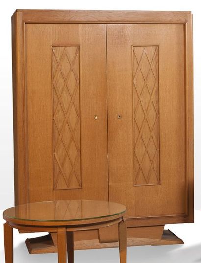 André ARBUS (1903-1969) Armoire en chêne vernissé à corps quadrangulaire ouvrant...