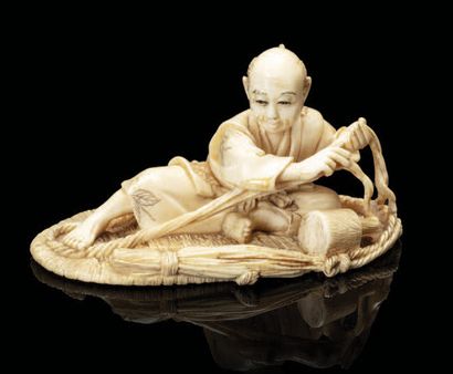 JAPON Okimono-netsuke en ivoire, représentant un artisan assis sur une getta géante...