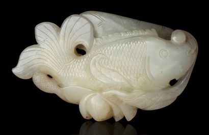 CHINE Galet en jade blanc sculpté en forme d'un poisson tenant une tige de lotus...