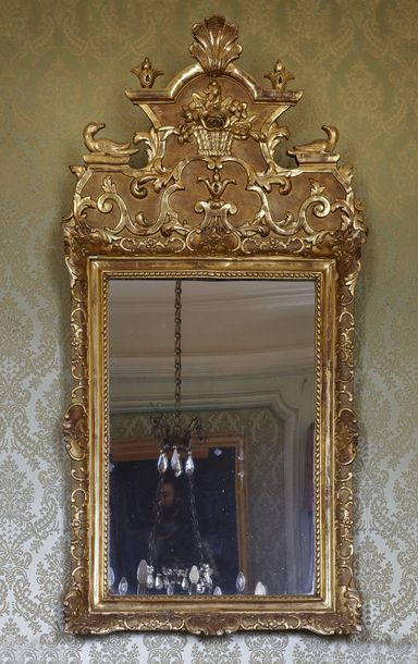 null Grand miroir à fronton 

en bois doré mouluré et sculpté à décor d'un bouquet...