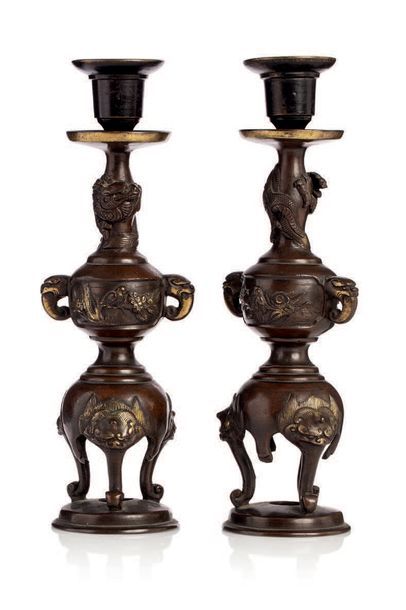 JAPON vers 1900 
Paire de bougeoirs en bronze, reposant sur trois pieds crachés par...