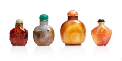 CHINE XXe siècle Quatre flacons tabatières en agate, l'un de couleur miel et ambre,...