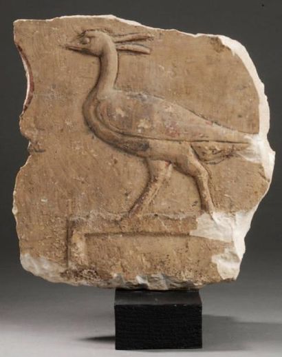 EGYPTE Fragment en bas-relief sculpté d'un héron reposant sur une base. Pierre calcaire...