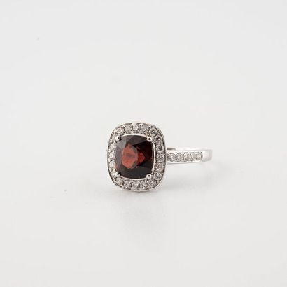 null 750°/00 white gold ring set with the claws of a square cushion-cut garnet weighing...