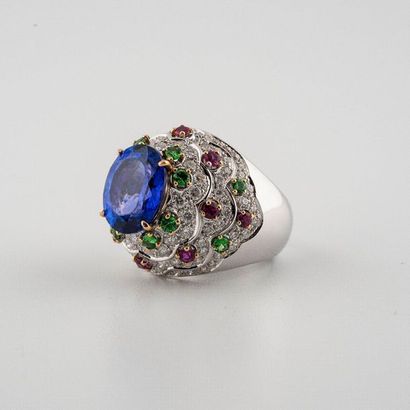 null 750°/00 white gold dome ring set with an oval-cut tanzanite enhanced by a paving...