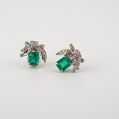 null Earrings each set with an emerald cut emerald with cut sides topped with a knot...