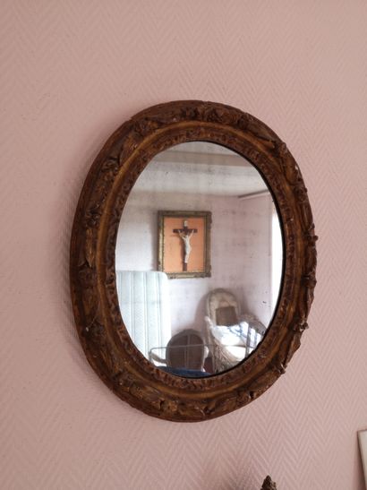 Miroir ovale en bois sculpté et doré à décor...