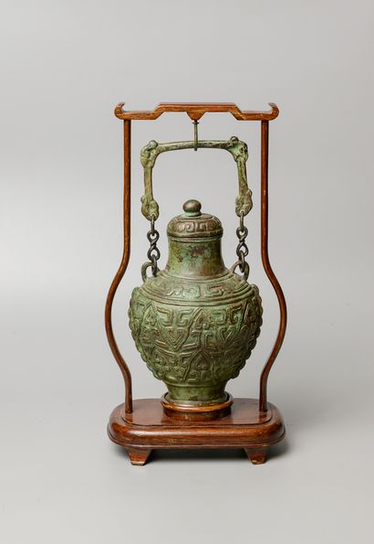  CHINE, XXème siècle. Vase balustre couvert de style archaisant suspendu par une...