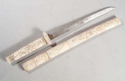  JAPON, XXème siècle. Long couteau monté en résine sculptée de scènettes. Long :...