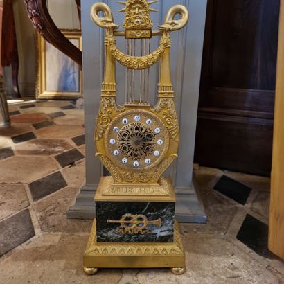 Lyre clock in chased and gilded bronze, decorated...