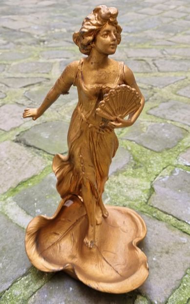 Woman with a fan. Sculpture in gilded metal....