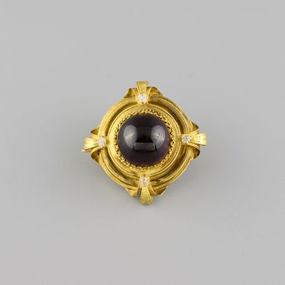 Yellow gold brooch centered with a garnet...