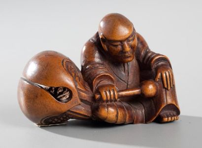 null Netsuke en buis représentant un moine assis endormi contre un mokugyo le bâton...