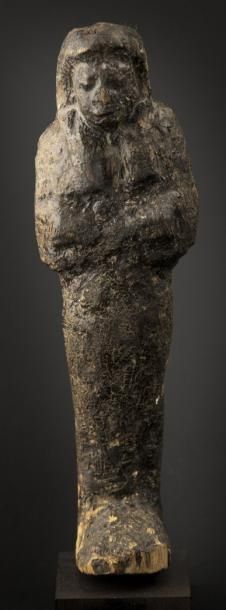 EGYPTE Oushebti momiforme enmailloté, coiffé dela pérruque tripartite. H: 17,5 cm....