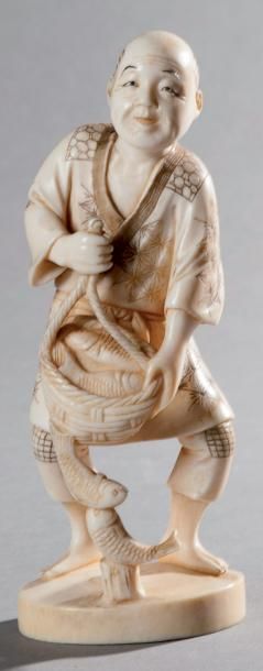 Okimono en ivoire représentant un homme portant...