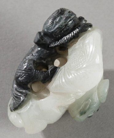 null Pendentif en jade blanc et noir sculpté de deux chiens. Chine, début XXème siècle....