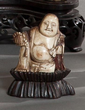 null Statuette en ivoire anciennement laquée repré­sentant un bouddha assis tenant...