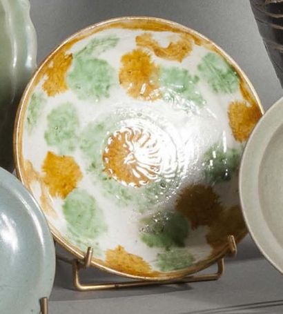 null Coupe plate en céramique émaillée sancai, à décor floral stylisé ocre et vert...