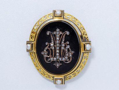 null Broche ovale en or repercé de rinceaux, centrée d'un médaillon d'onyx appliqué...