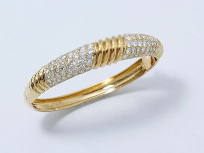null Beau bracelet jonc rigide ouvrant en or godronné, habillé de 2 pavages de diamants...