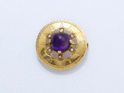 null Broche ronde en or 18 K guilloché, centrée d'un cabochon d'améthyste en serti...