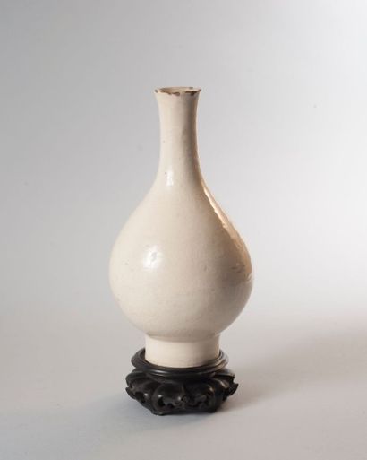 null Petit vase en porcelaine émaillé crème à décor incisé sous couverte de rinceaux.

Chine,...