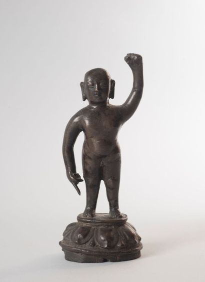 null Sujet en bronze de patine brune représentant le Bouddha enfant, debout sur un...