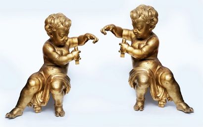  Importante paire d'amours en bois sculpté et doré. Ils sont représentés drapés,...