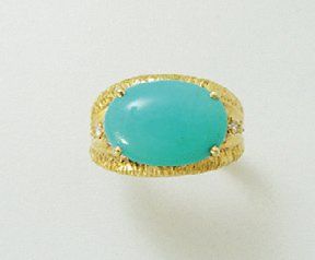 null Bague en or guilloché, ornée d'une turquoise cabochon en serti griffe, épaulée...