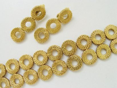 null Ensemble en or, composé d'un bra­celet à décor de pastilles «paillette» ajourées,...