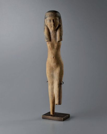 Statuette féminine portant une coiffe tripartite....