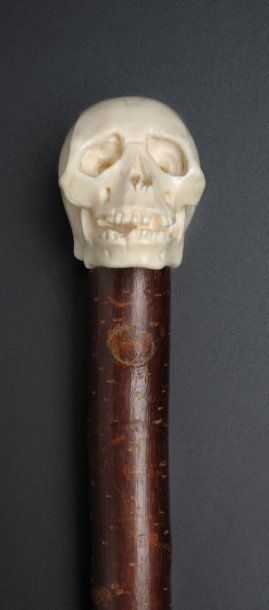 null Belle canne à pommeau en ivoire sculpté repré­sentant un crâne humain primitif....