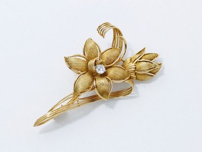 null Broche stylisée en or 750 millièmes représentant une fleur ponctuée d'un diamant...