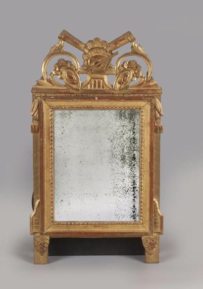 null Petit miroir en bois sculpté et 

doré, surmonté d’un fronton ajouré à 

décor...