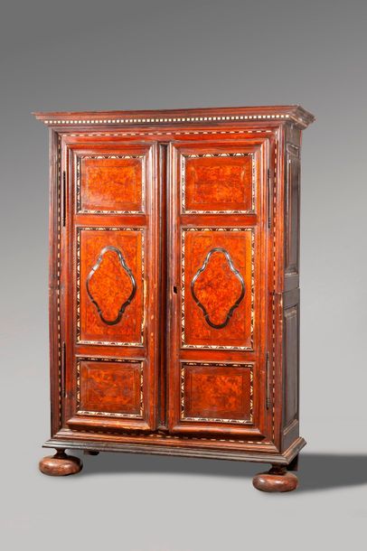 null PETITE ARMOIRE en noyer mouluré et placage de ronce de noyer dans des cartouches....