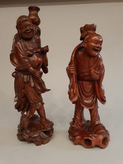 null Paire de personnages en bois sculpté figurant un porteur de gourde et de lotus....