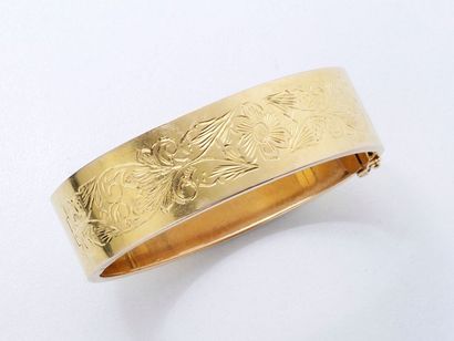 null Bracelet jonc rigide ouvrant à charnière en or 750 millièmes, à décor ciselé...
