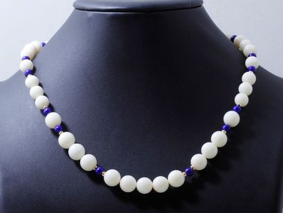 null Collier composé d'un rang de perles de corail blanc et de perles de lapis lazuli....