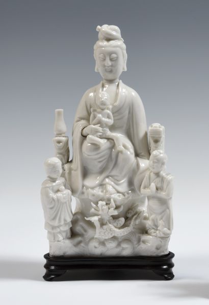 null 
China

Figure of Guanyin seated on a rock, carrying a child on her lap, between...