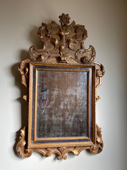  Wood and gilded stucco mirror decorated with a blue frieze, decorated with foliage...