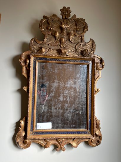  Wood and gilded stucco mirror decorated with a blue frieze, decorated with foliage...