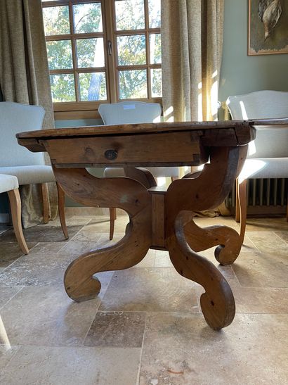  Table guéridon en bois naturel reposant sur un piétement en bois à décor de volute...