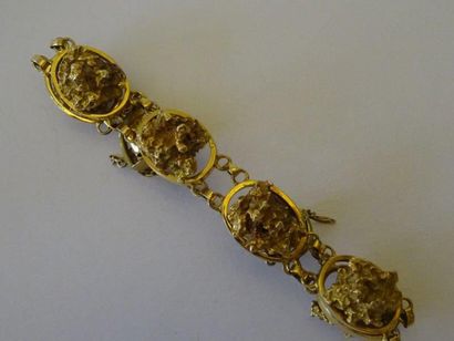 null A: Bracelet articulé en or jaune (18 carats) à décor simulant des pépites d'or....