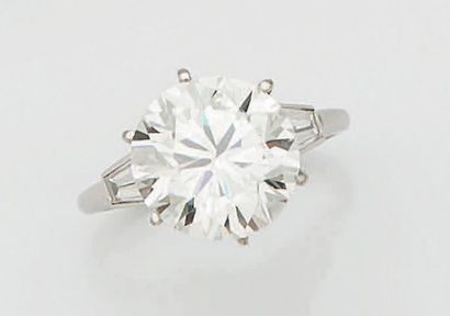 null BAGUE DIAMANT Ornée d'un diamant rond pesant 6,41 carats épaulé de chaque côté...
