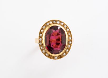 null Gold ring set with a cushion-cut garnet in a circle of pearl buttons.
(missing,...