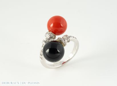 null Crossed ring in 750°/°° white gold set with a ball of coral and onyx enhanced...