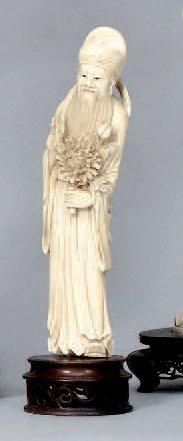 null Sujet en ivoire représentant un dieu du Tao tenant un chrysanthème. Chine. H.:...