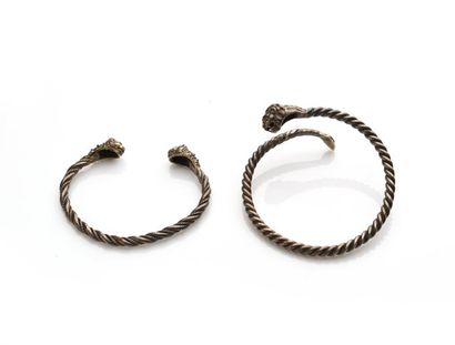 null Deux bracelets joncs torsadés en argent (950 millièmes) à décor de tête de lions....