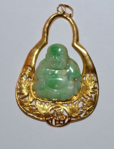  Pendentif en or 750 °/°° orné d'un bouddha en jade. Poids brut. 13,4 g.