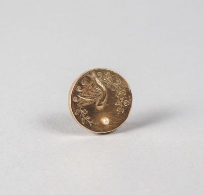 null Broche ronde ciselée d'une hirondelle en or 750 °/°° rehaussée d’une perle bouton,...